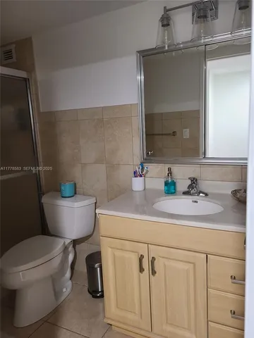 a bathroom with a granite countertop toilet sink and mirror
