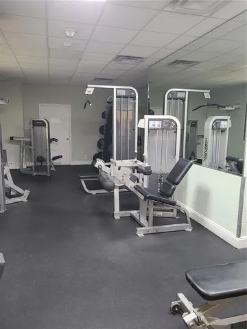 a room with gym equipment and large mirror