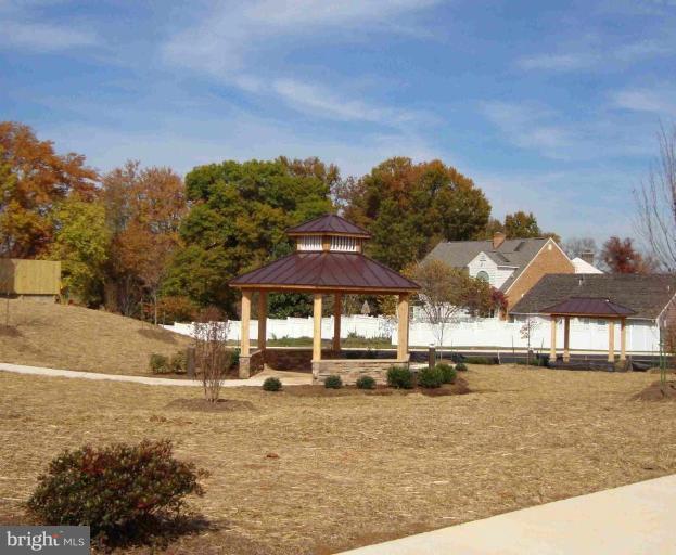 1801 Berry Ridge Drive, Unit 240 Culpeper, VA 22701 - Photo 14 of 16 a backyard of a house with table and chairs under an umbrella