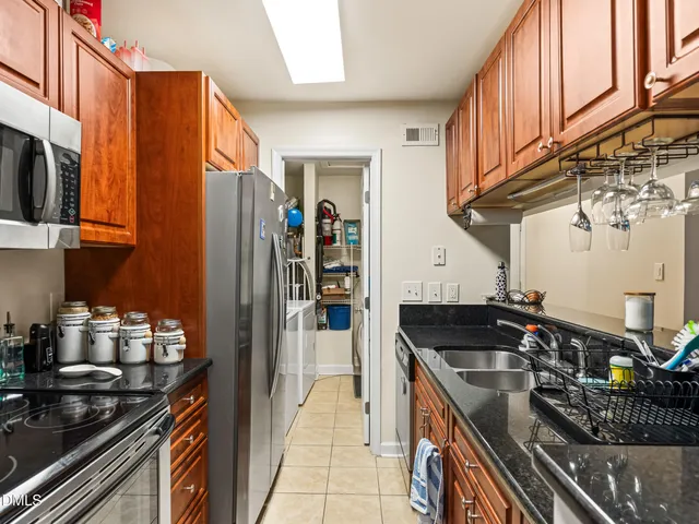 a kitchen with granite countertop a sink a stove and cabinets