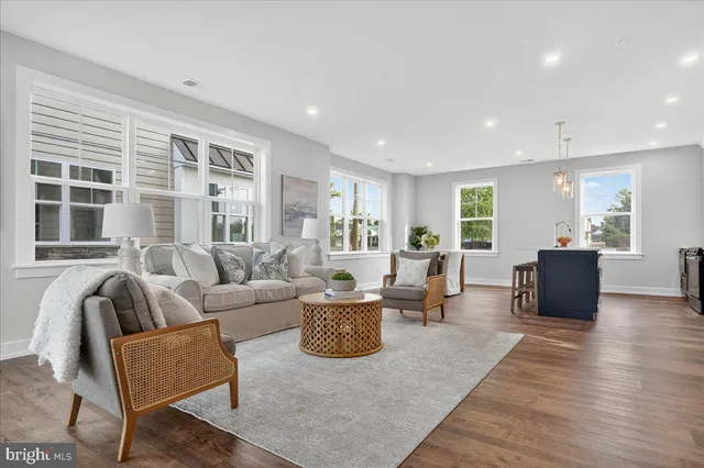 a living room with furniture a large window and wooden floor