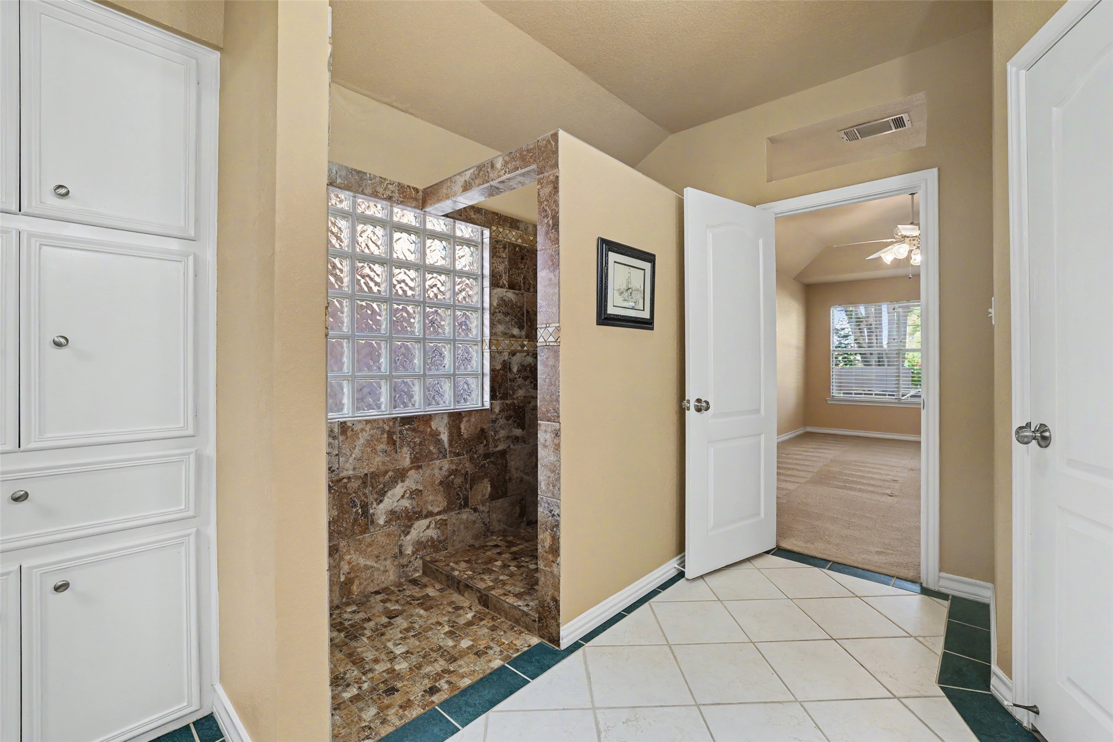 30107 Hamlet Circle Georgetown, TX 78628 - Photo 19 of 40 A convenient walk-in shower with natural light connects to a spacious bedroom.