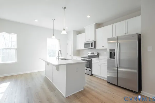 a kitchen with white cabinets stainless steel appliances and a center island
