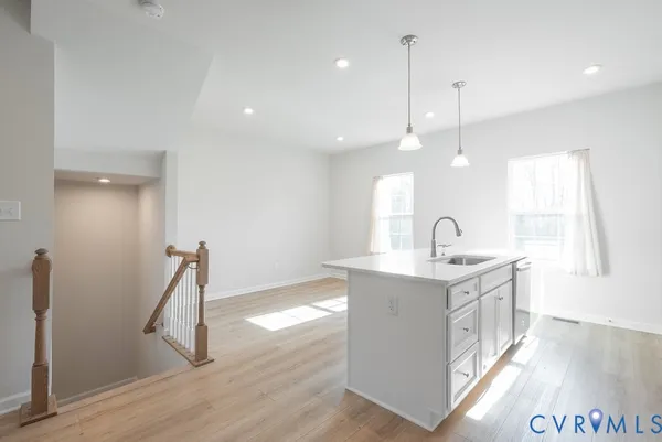 a kitchen with a sink stove and wooden floor