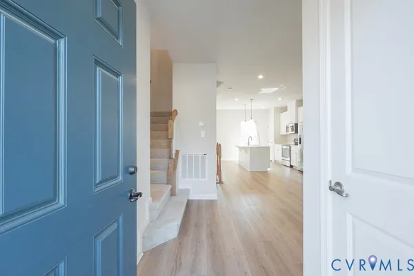 a view of a hallway with wooden floor windows and a bathroom
