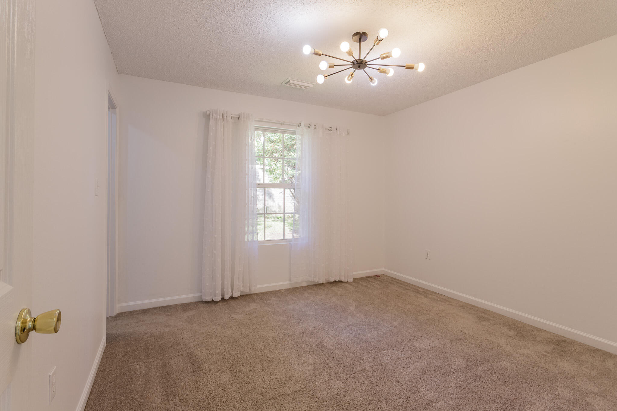 2233 Lewis Street Crestview, FL 32536 - Photo 14 of 24 an empty room with windows and chandelier fan