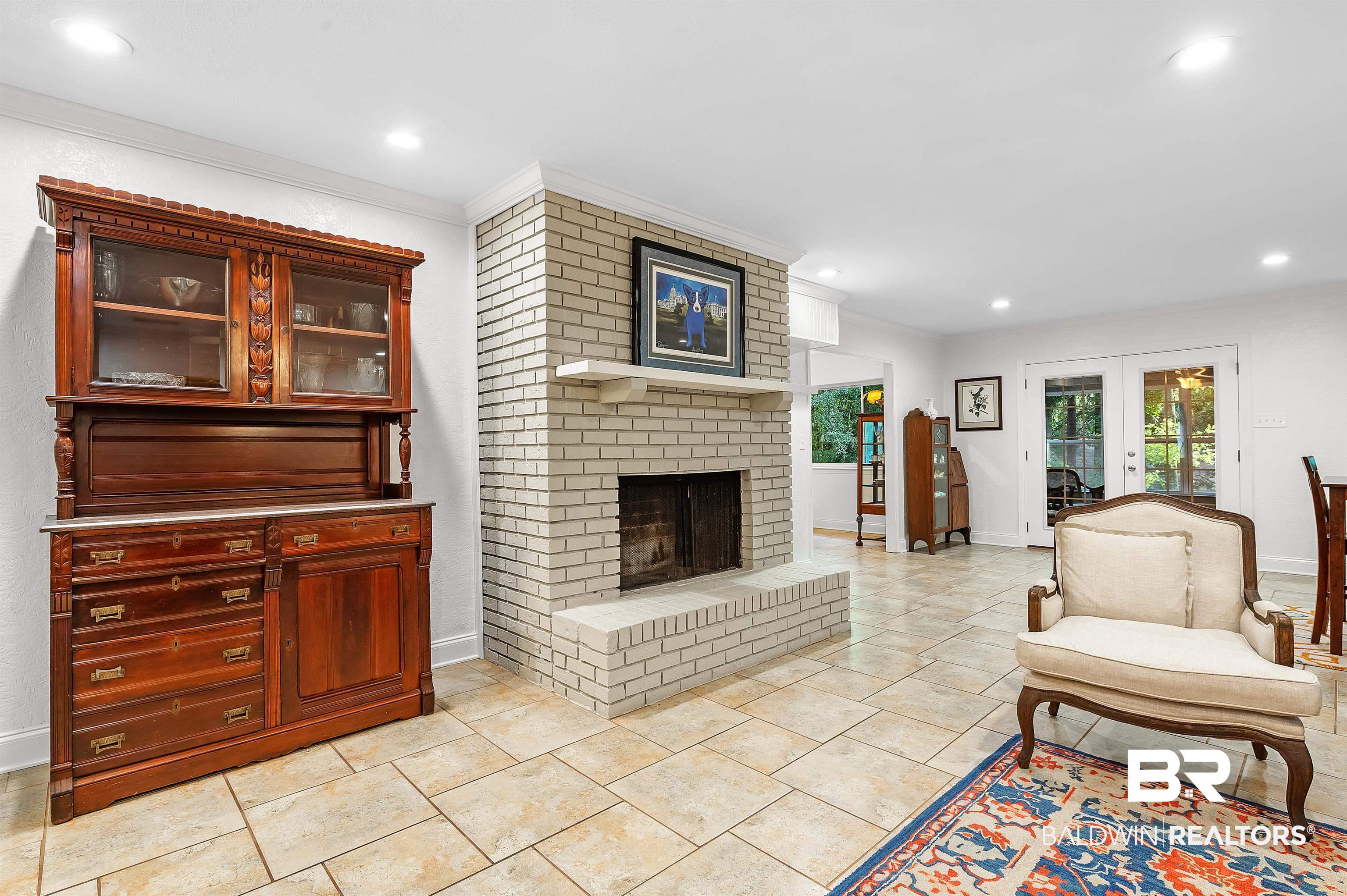 104 James Circle Daphne, AL 36526 - Photo 28 of 62 Tiled living room featuring brick wall, ornamental molding, a brick fireplace, and french doors