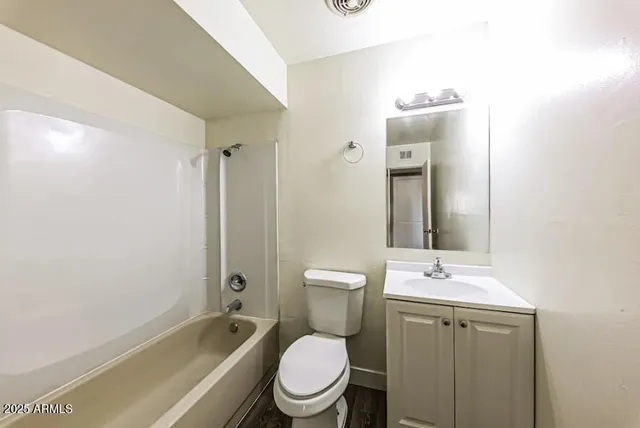 a bathroom with a toilet a sink a mirror a bathtub and shower