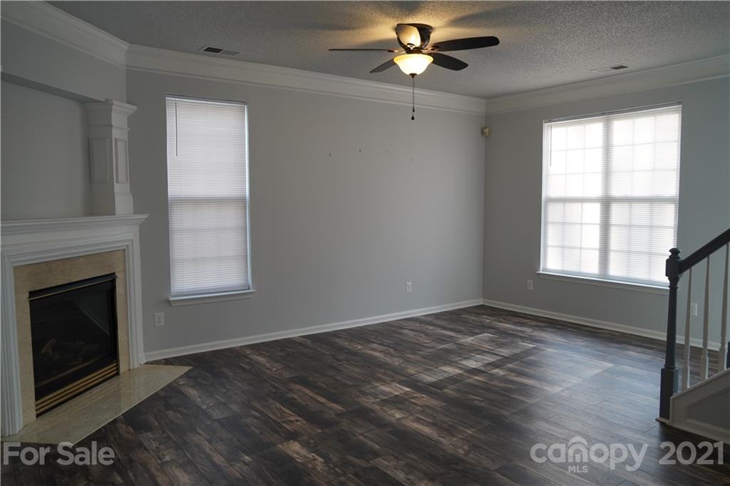 15220 Leslie Brooke Road Huntersville, NC 28078 - Photo 6 of 20 a view of an empty room with wooden floor fireplace and a window