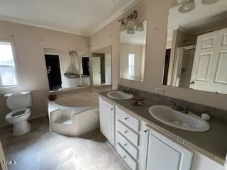 a spacious bathroom with a granite countertop double vanity sink a mirror and a toilet