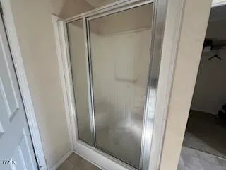 a bathroom with a glass door shower and vanity