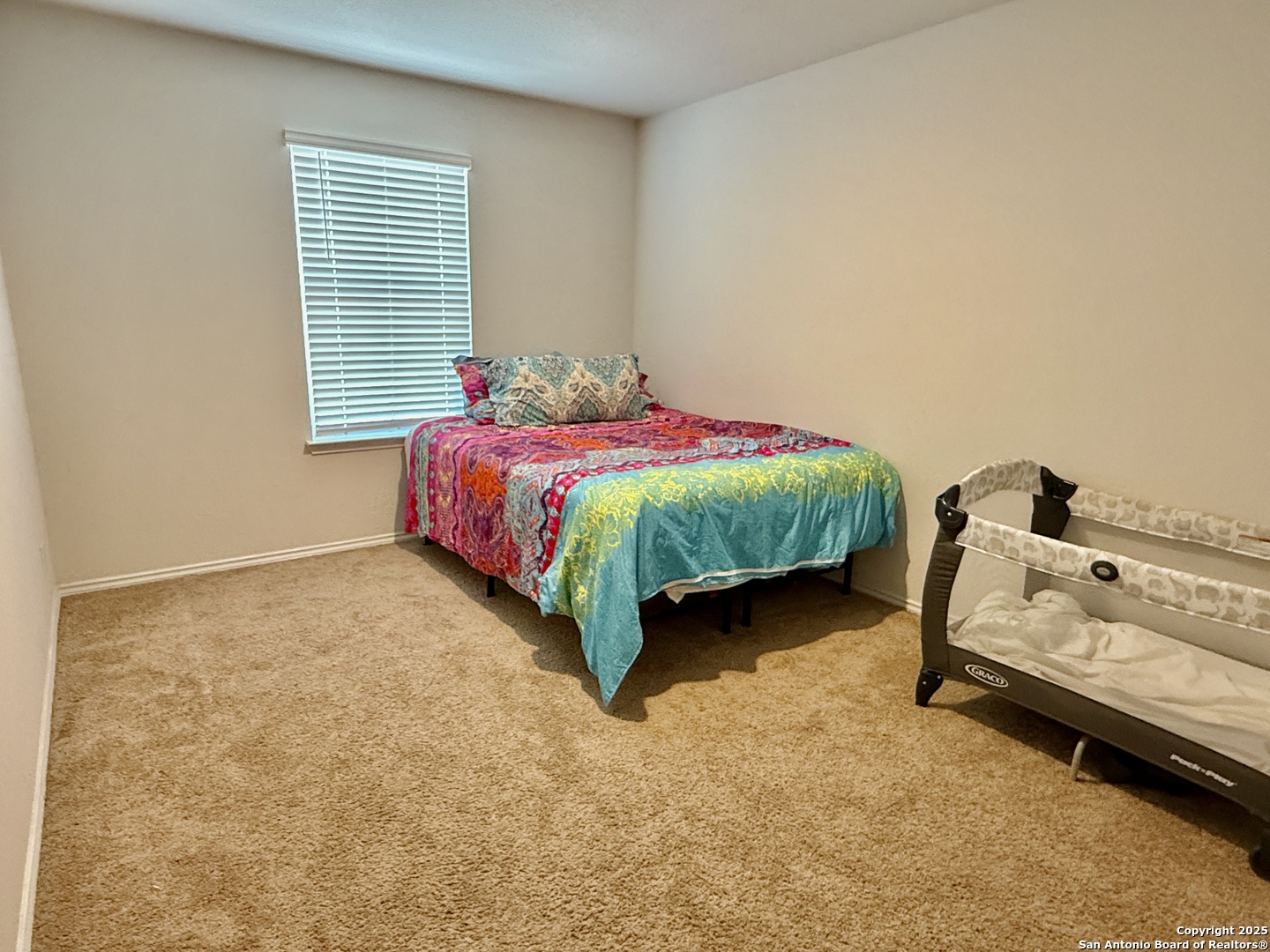 4002 Winterfell Pass Converse, TX 78109 - Photo 31 of 35 a spacious bedroom with a bed and a window