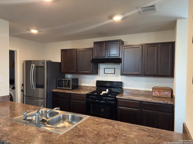 a kitchen with granite countertop stainless steel appliances and wooden cabinets