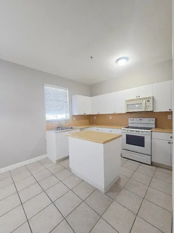 a kitchen with a stove top oven and cabinets