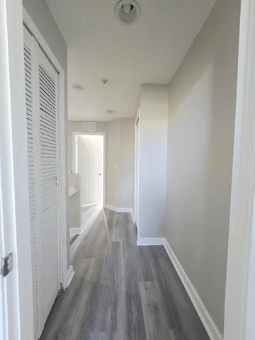 a view of a hallway with wooden floor
