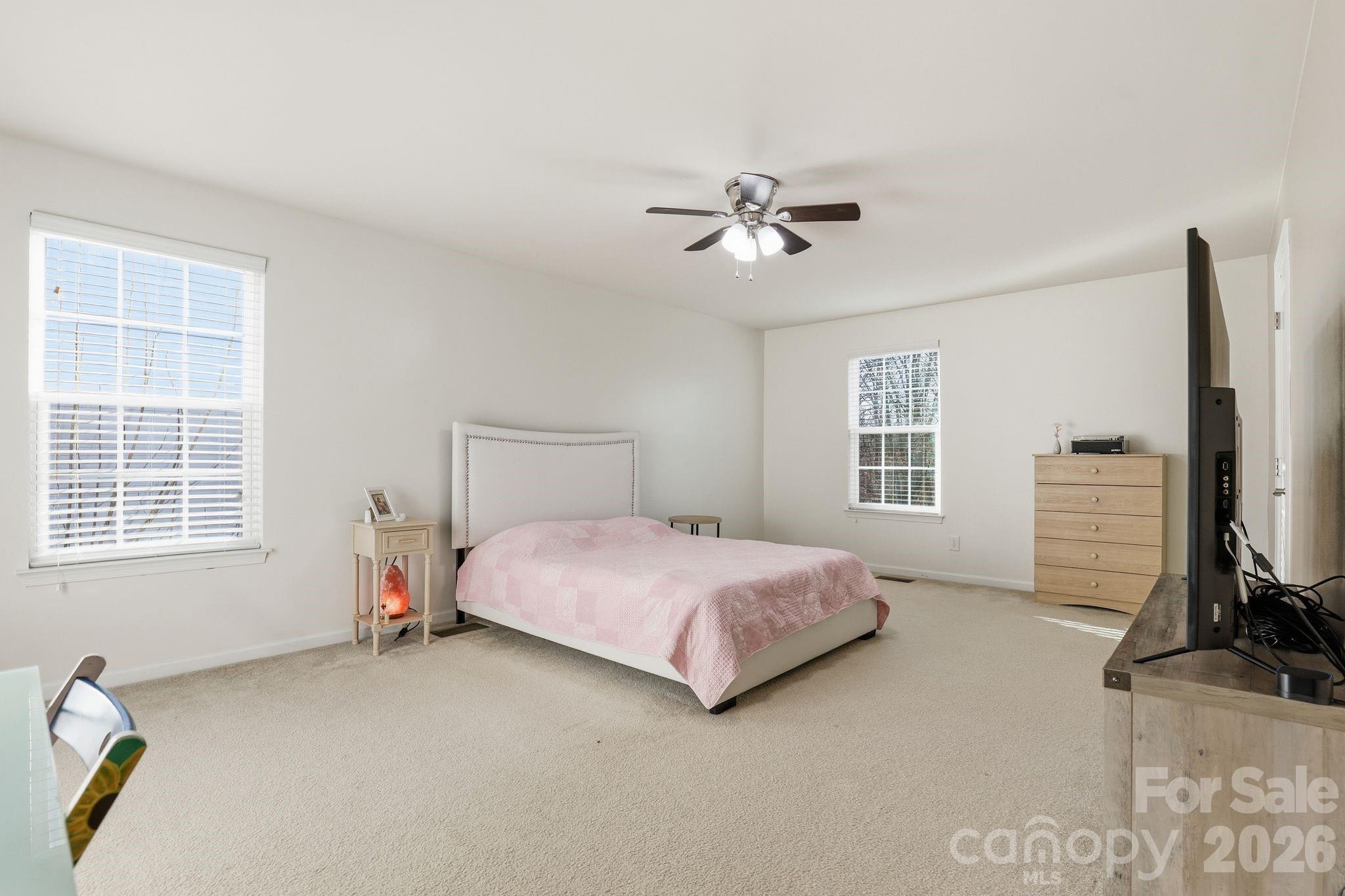 7532 West Berkeley Road, Unit 25 Denver, NC 28037 - Photo 17 of 36 a bedroom with a bed flat screen tv and windows