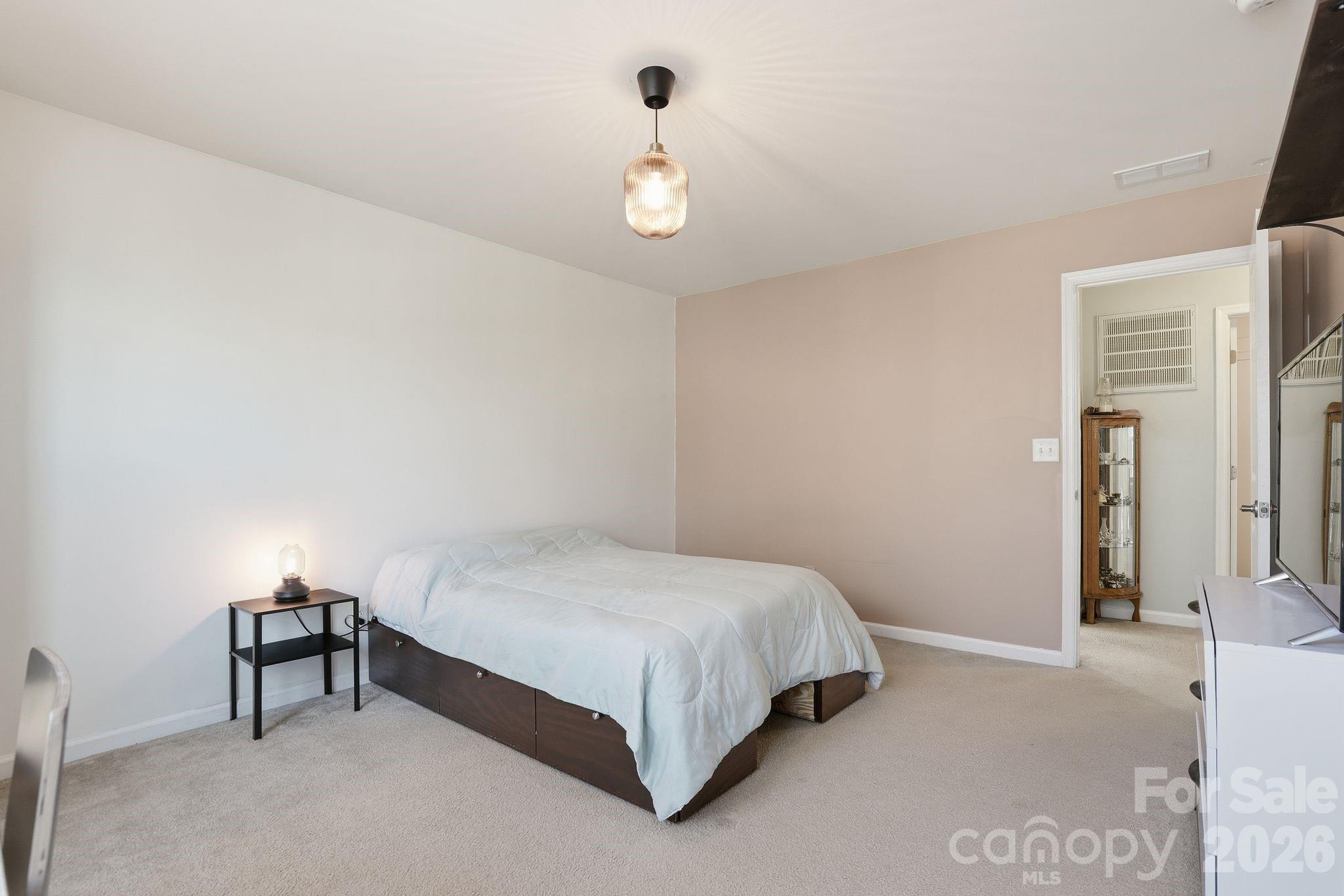 7532 West Berkeley Road, Unit 25 Denver, NC 28037 - Photo 22 of 36 a bedroom with a bed and a chandelier