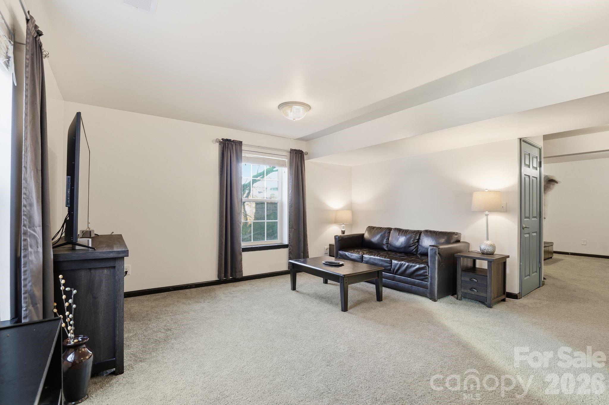 7532 West Berkeley Road, Unit 25 Denver, NC 28037 - Photo 28 of 36 a living room with furniture a piano and a flat screen tv