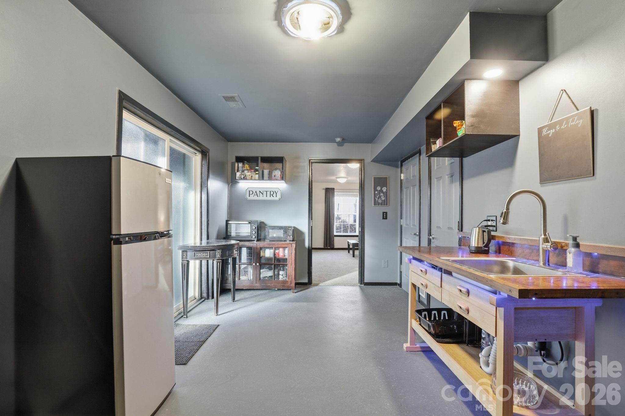 7532 West Berkeley Road, Unit 25 Denver, NC 28037 - Photo 31 of 36 a kitchen with refrigerator a table and chairs