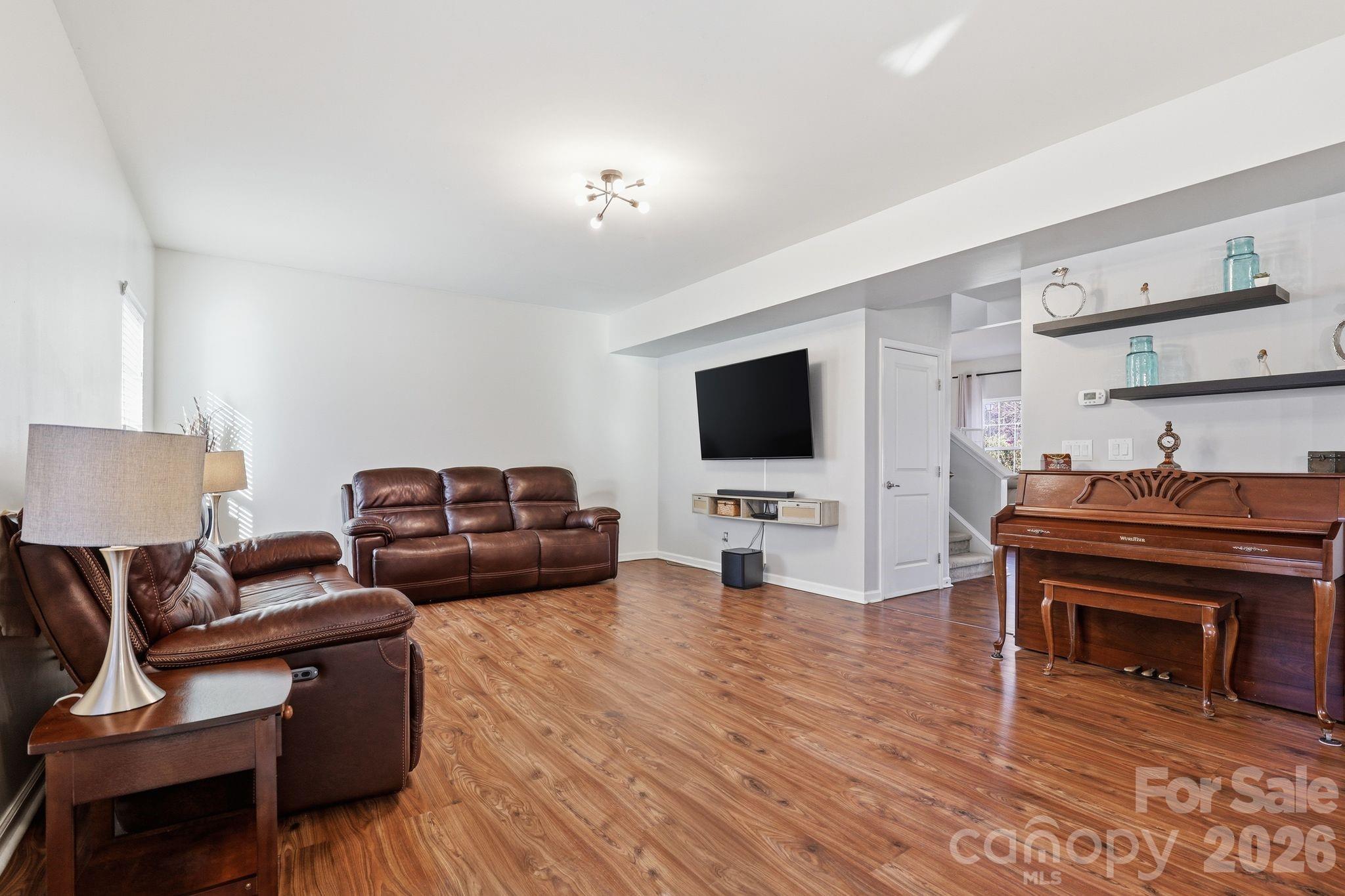7532 West Berkeley Road, Unit 25 Denver, NC 28037 - Photo 8 of 36 a living room with furniture and a flat screen tv