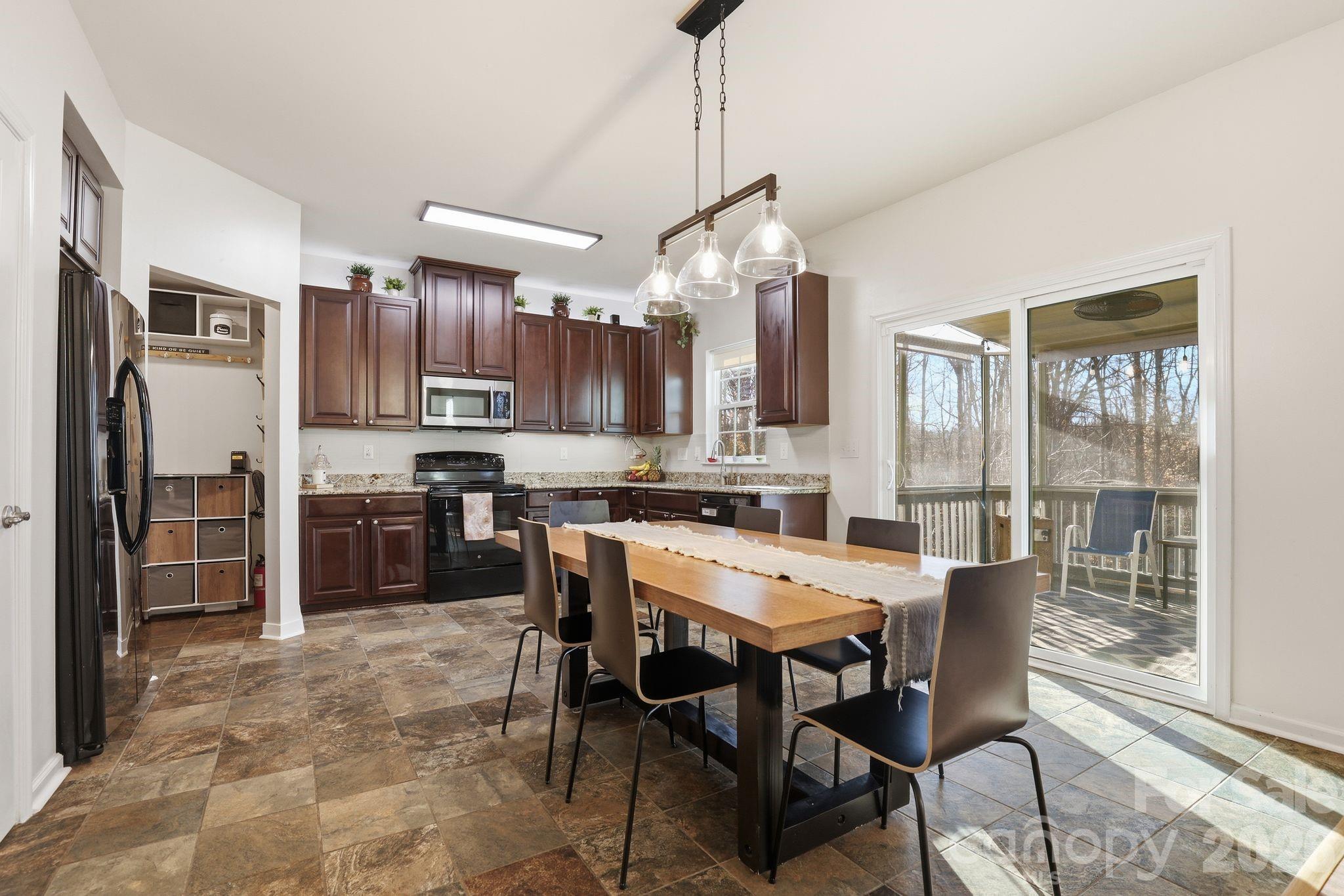7532 West Berkeley Road, Unit 25 Denver, NC 28037 - Photo 10 of 36 a kitchen with stainless steel appliances a table chairs refrigerator and cabinets