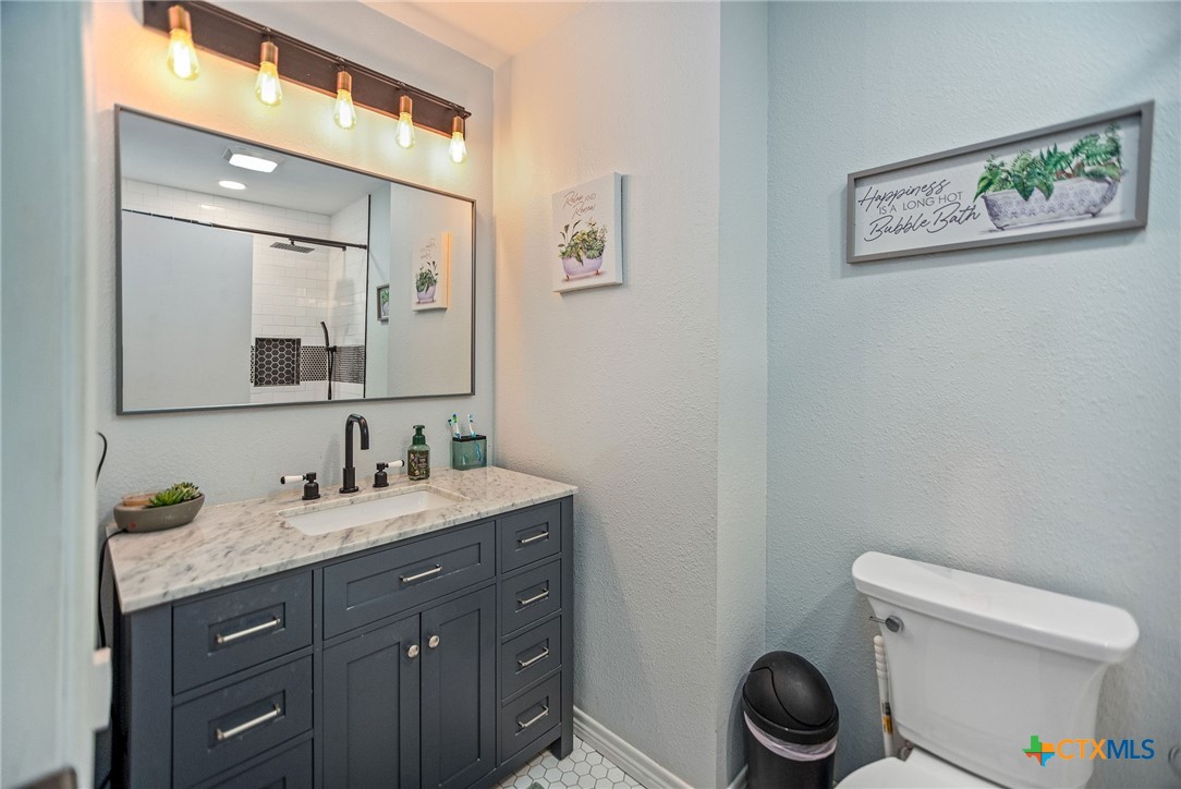 519 Travis Street Port Lavaca, TX 77979 - Photo 15 of 26 a bathroom with a toilet a sink and mirror
