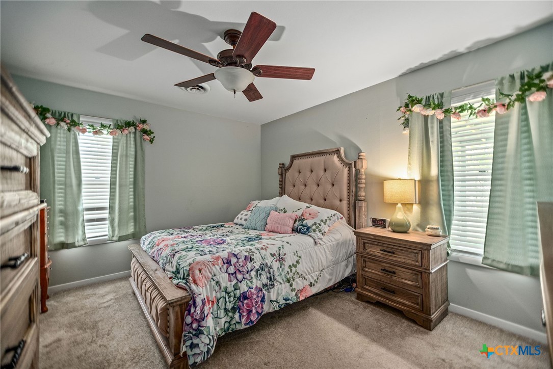 519 Travis Street Port Lavaca, TX 77979 - Photo 19 of 26 a bedroom with a bed next to a window and a chandelier