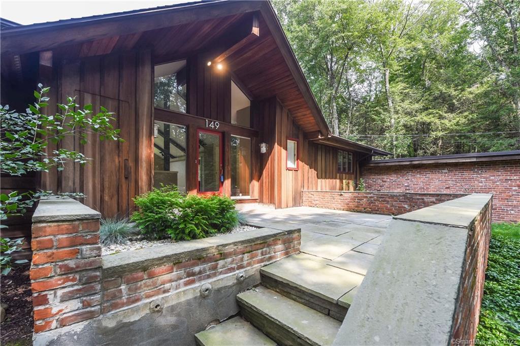 a view of a house with backyard and sitting area