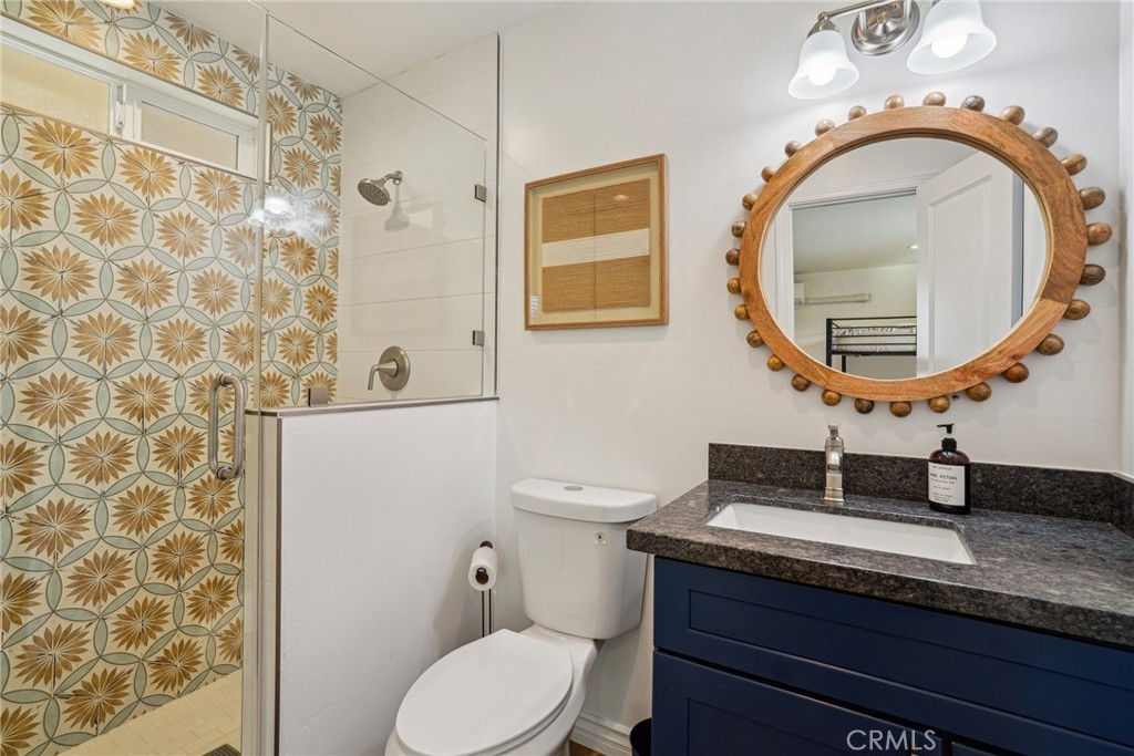 5235 Border Avenue Joshua Tree, CA 92252 - Photo 26 of 63 a bathroom with a granite countertop toilet a sink and mirror