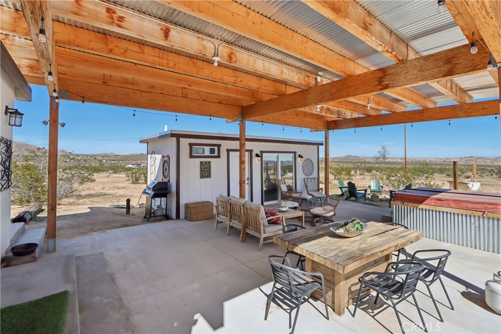 5235 Border Avenue Joshua Tree, CA 92252 - Photo 34 of 63 a view of a patio with a table and chairs and potted plants