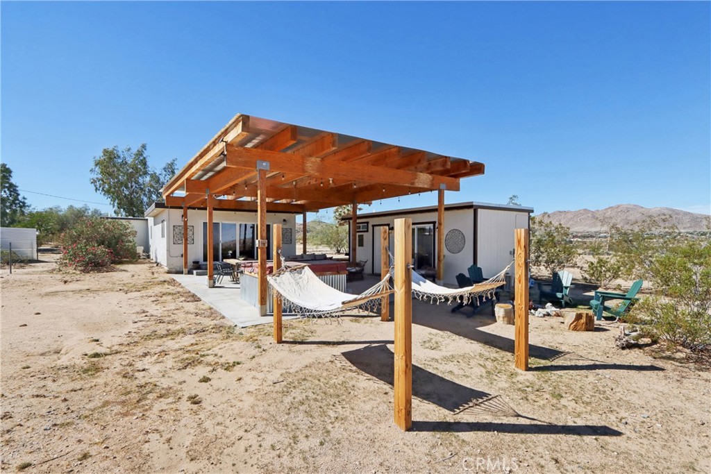 5235 Border Avenue Joshua Tree, CA 92252 - Photo 39 of 63 a patio with a table and chairs under an umbrella