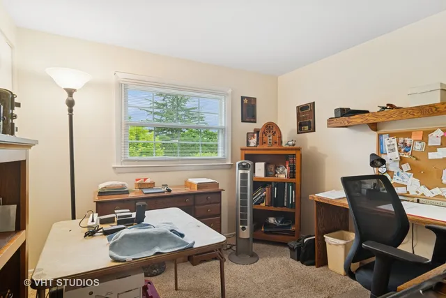 a view of a workspace with furniture and a window