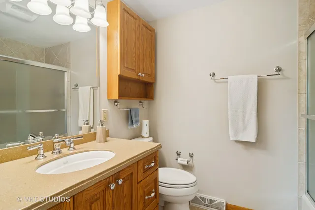 a bathroom with a granite countertop sink toilet and shower