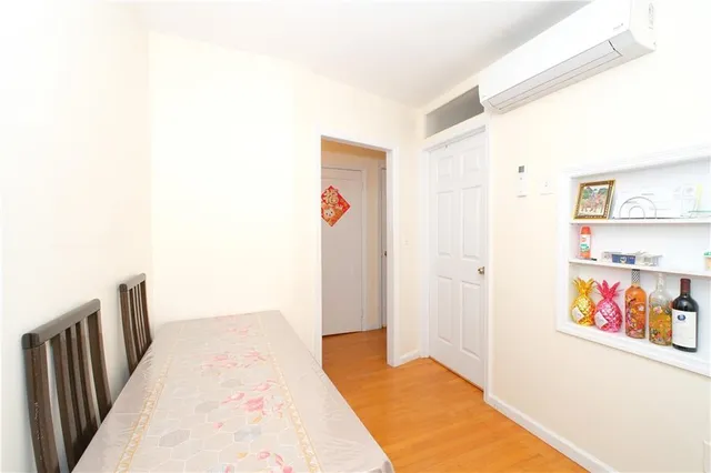 a view of a hallway with wooden floor and cabinet