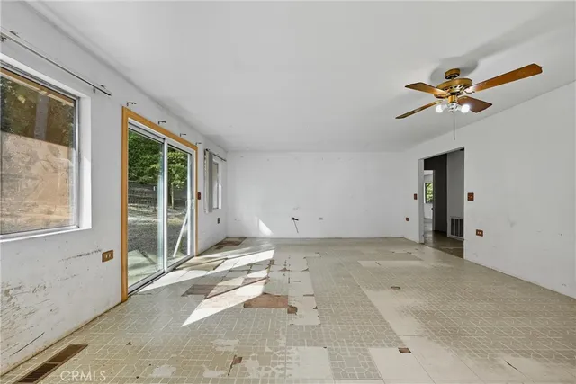 a view of a room with a ceiling fan and window