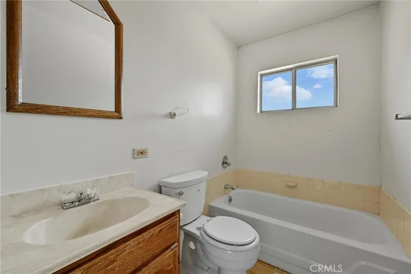 a bathroom with a granite countertop toilet a sink and bathtub