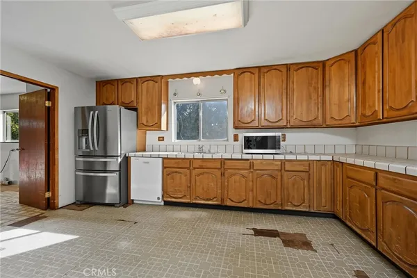 a kitchen with stainless steel appliances granite countertop a refrigerator a stove a sink and dishwasher