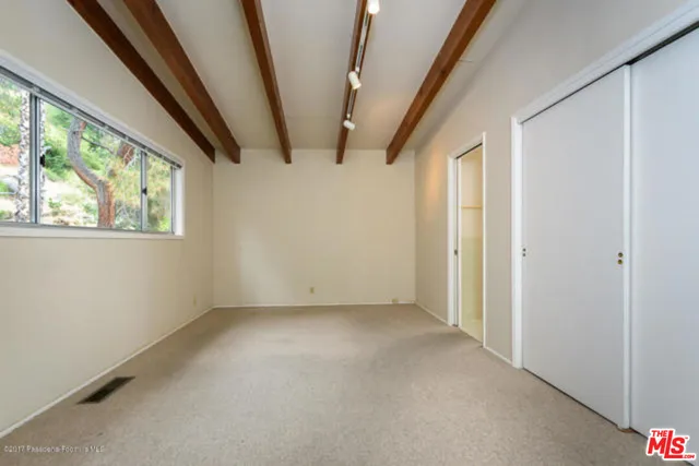 a view of a big room with windows and chandelier fan