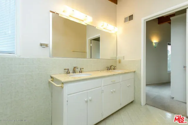 a bathroom with a granite countertop sink and a mirror