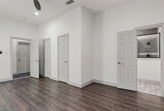 an empty room with wooden floor & closet area