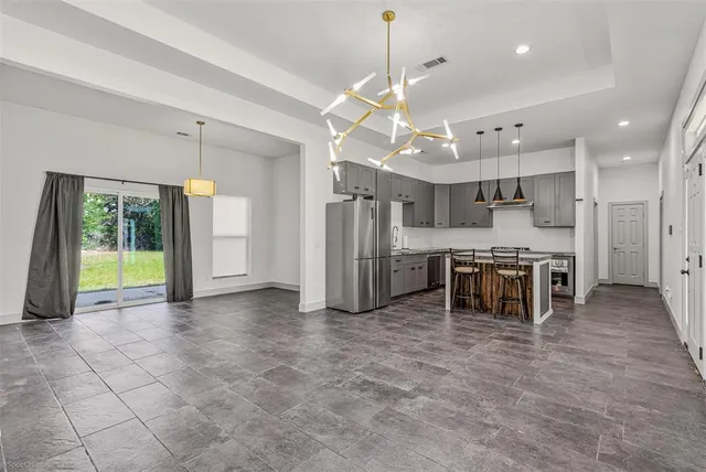 a large kitchen with a stove a refrigerator a sink a oven and a large window