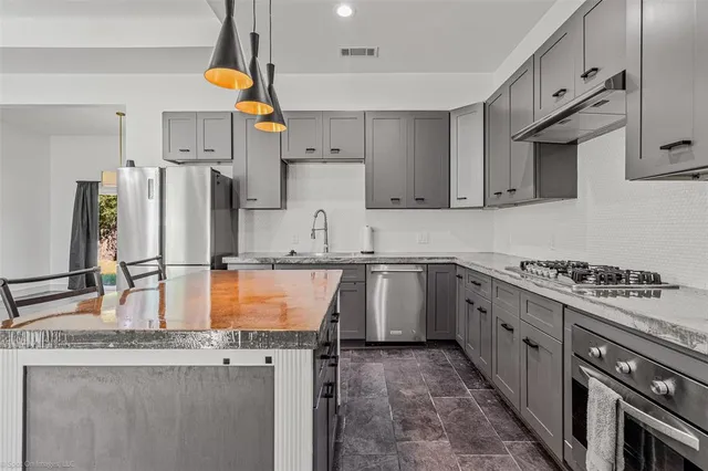 a kitchen with refrigerator a stove a sink and cabinets