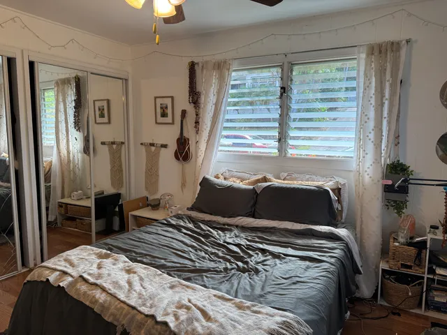 a bedroom with a bed and a chandelier next to a window