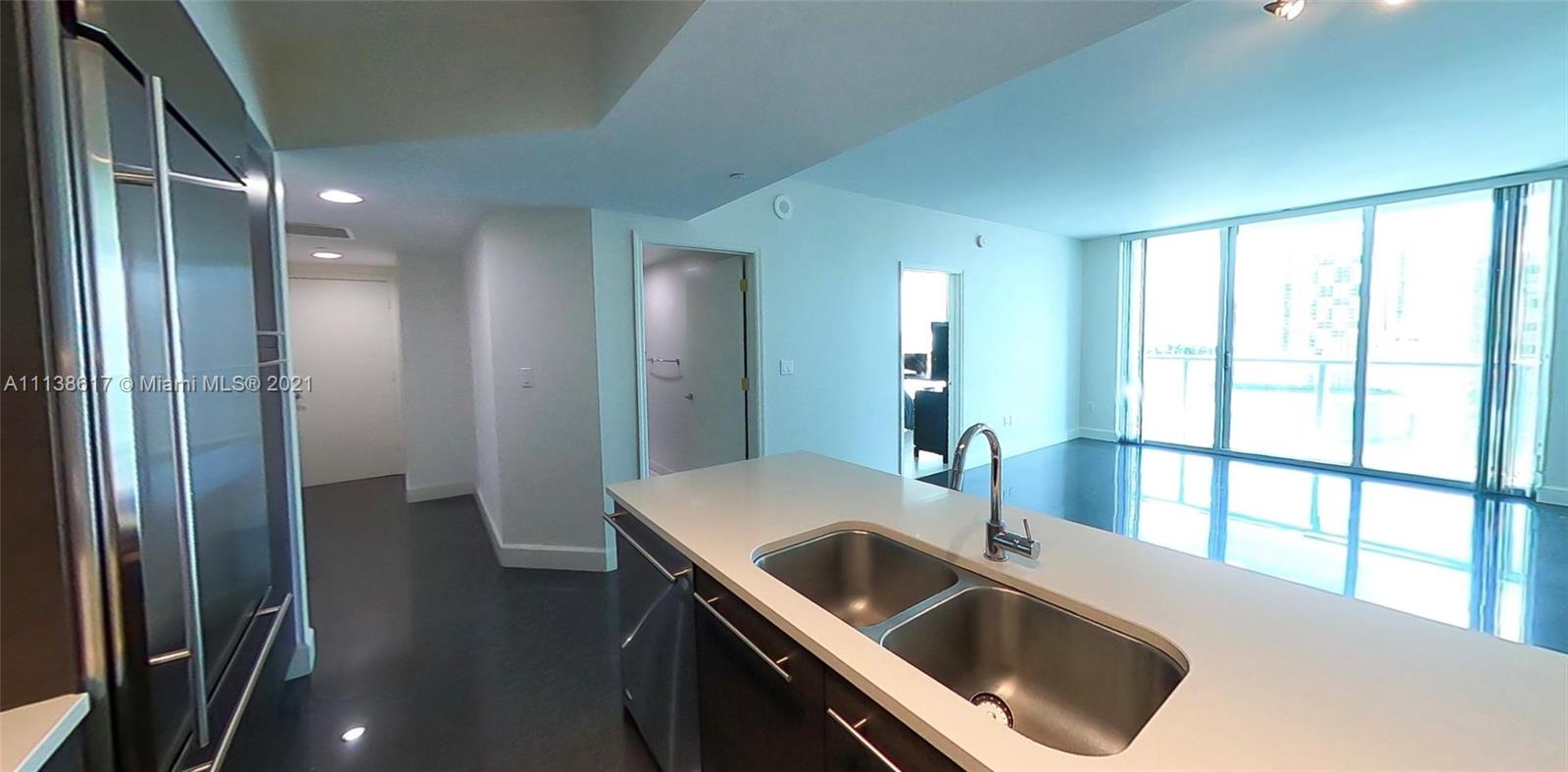 55 Southeast 6th Street, Unit 1903 Miami, FL 33131 - Photo 2 of 23 a kitchen with a sink and large mirror