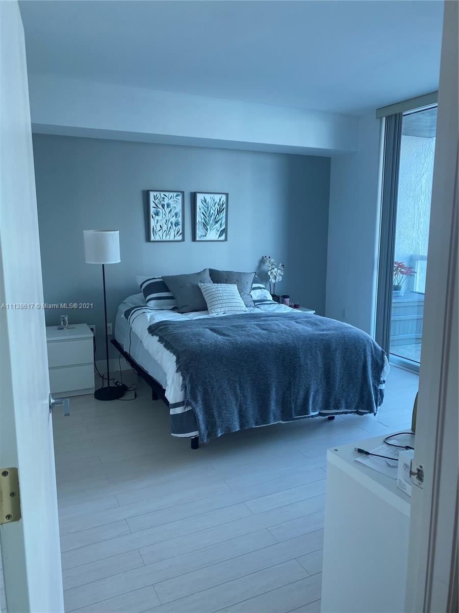 55 Southeast 6th Street, Unit 1903 Miami, FL 33131 - Photo 12 of 23 a bedroom with a bed and a night stand