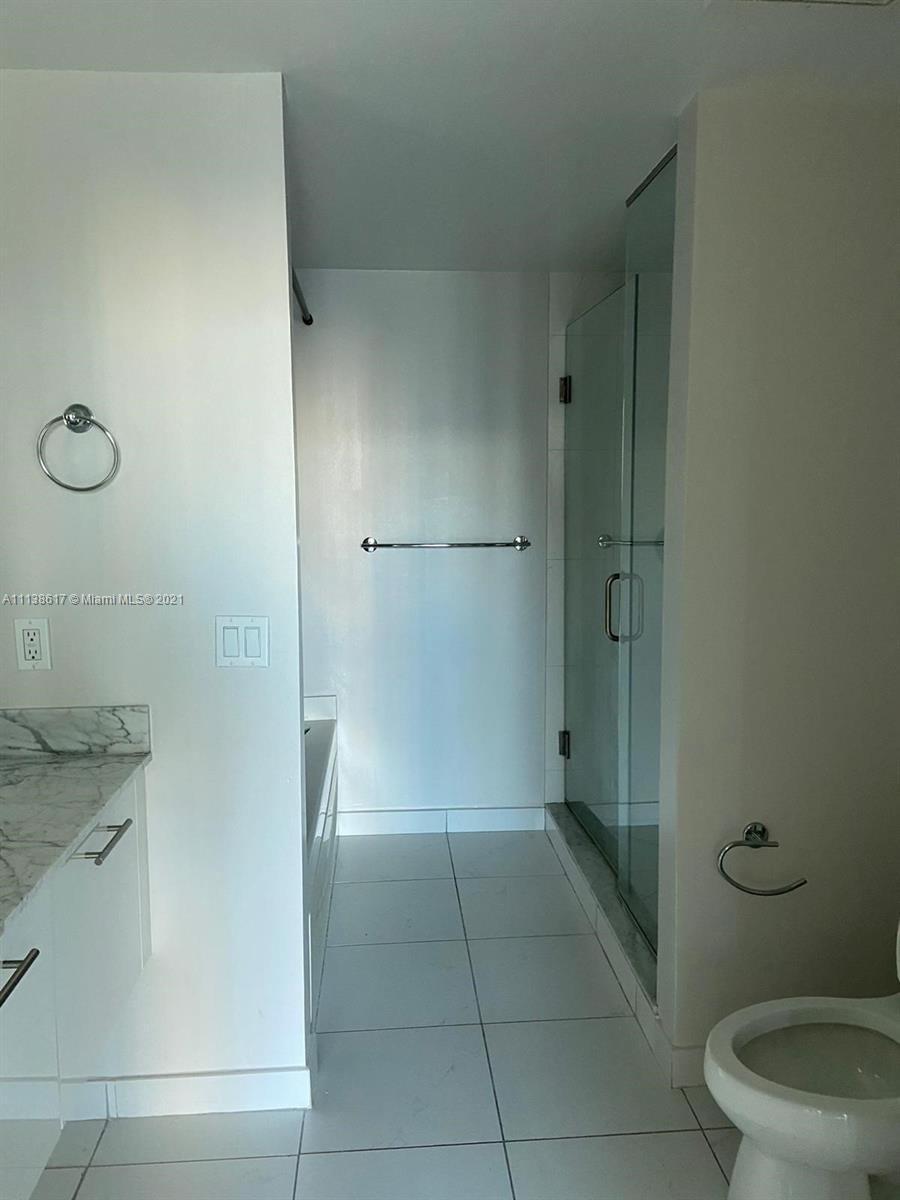 55 Southeast 6th Street, Unit 1903 Miami, FL 33131 - Photo 14 of 23 a bathroom with a granite countertop sink a toilet and shower