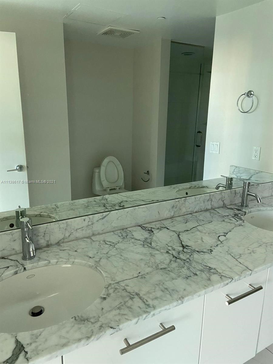 55 Southeast 6th Street, Unit 1903 Miami, FL 33131 - Photo 15 of 23 a bathroom with a sink and a mirror
