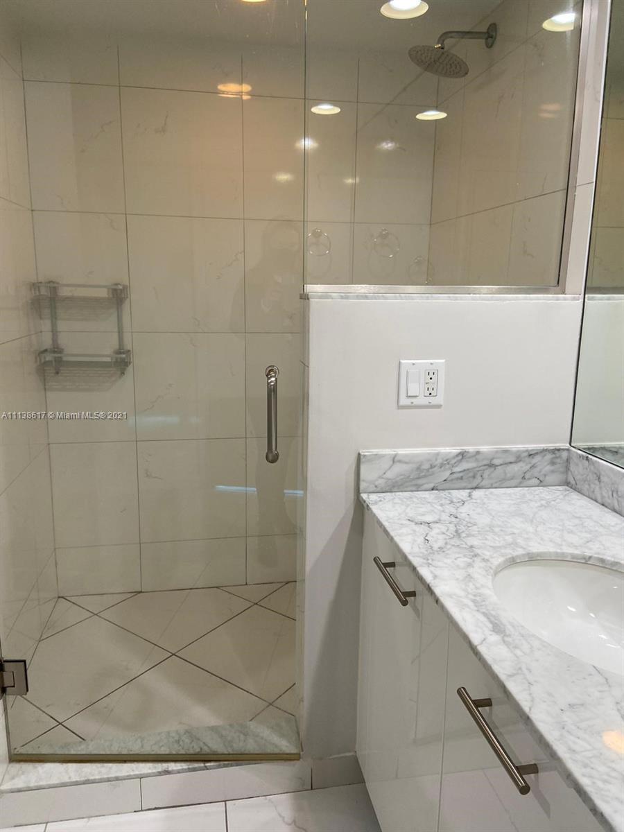 55 Southeast 6th Street, Unit 1903 Miami, FL 33131 - Photo 16 of 23 a bathroom with a granite countertop sink and a mirror