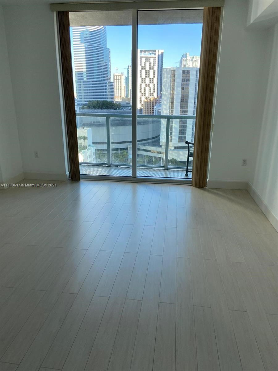 55 Southeast 6th Street, Unit 1903 Miami, FL 33131 - Photo 17 of 23 an empty room with wooden floor and windows