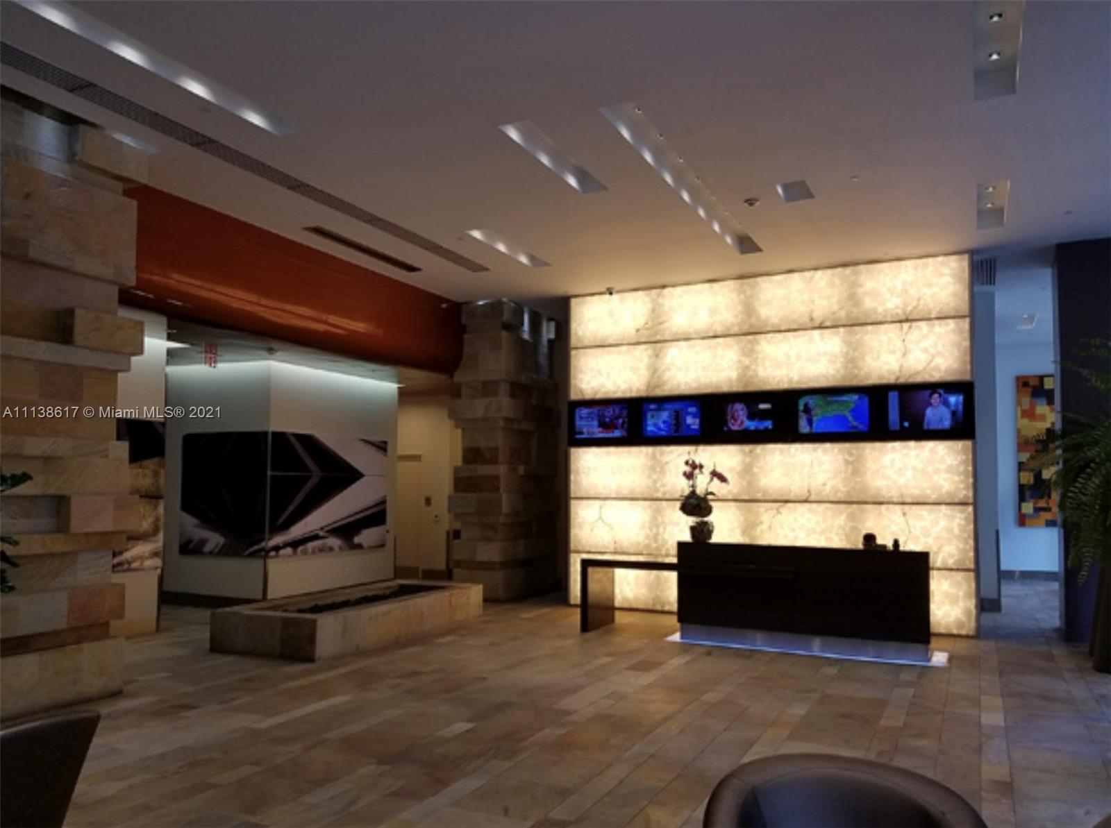 55 Southeast 6th Street, Unit 1903 Miami, FL 33131 - Photo 20 of 23 a living room with furniture and a flat screen tv